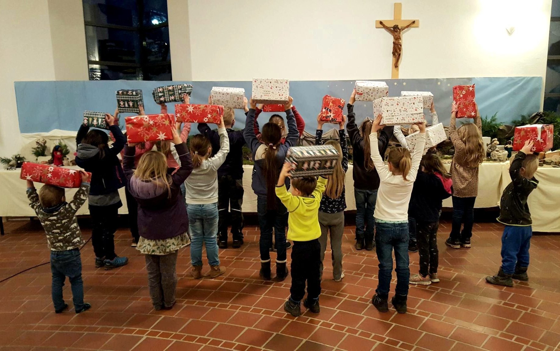 Kindergottesdienst-Kinder präsentieren Nikolauspäckchen, die sie für Flüchtlingskinder gepackt haben