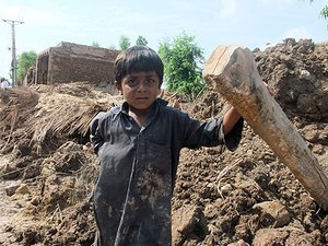 Junge vor zerstörtem Elternhaus in Pakistan